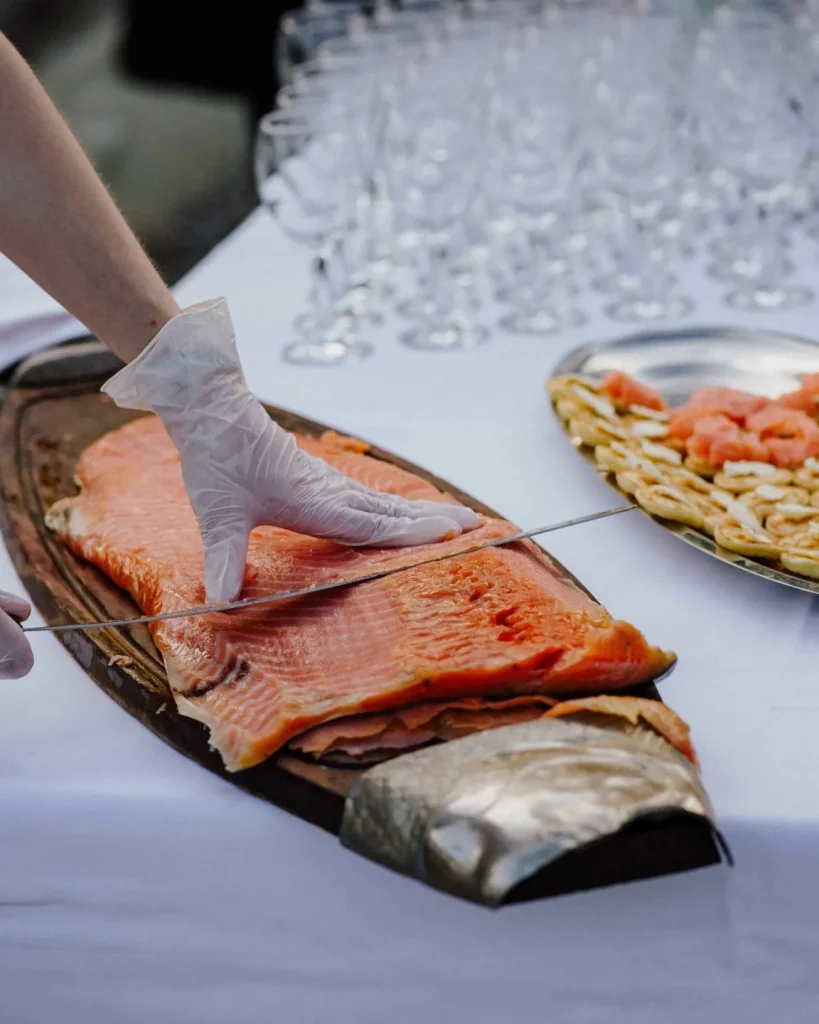 Découpe de filets de saumon fumé par la maison, banquet une de leurs spécialités savoureuse